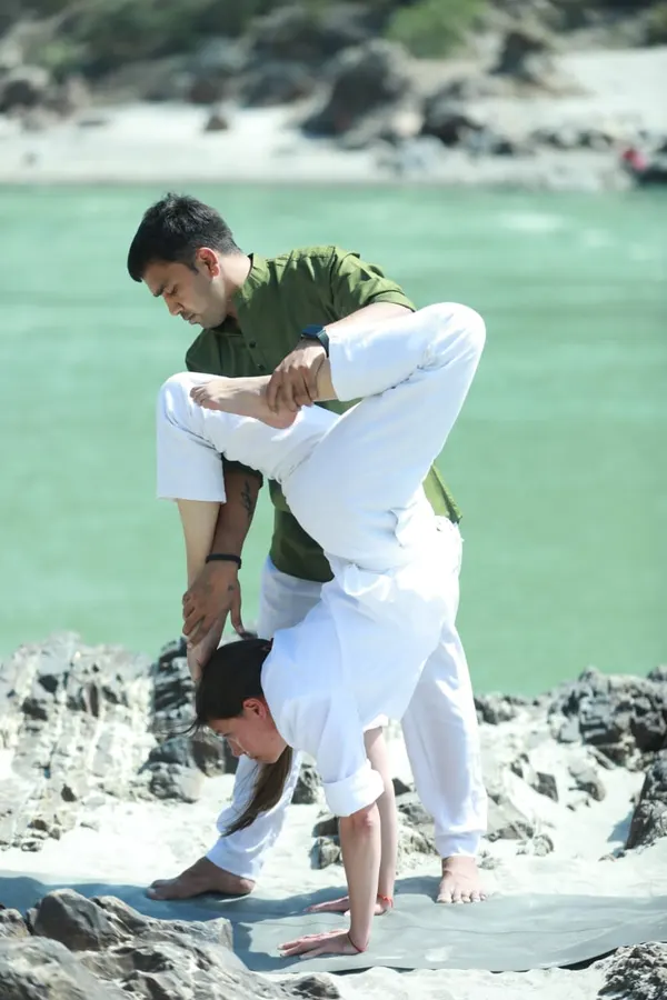 Yogacharye Vishal corrigiendo una postura junto al río